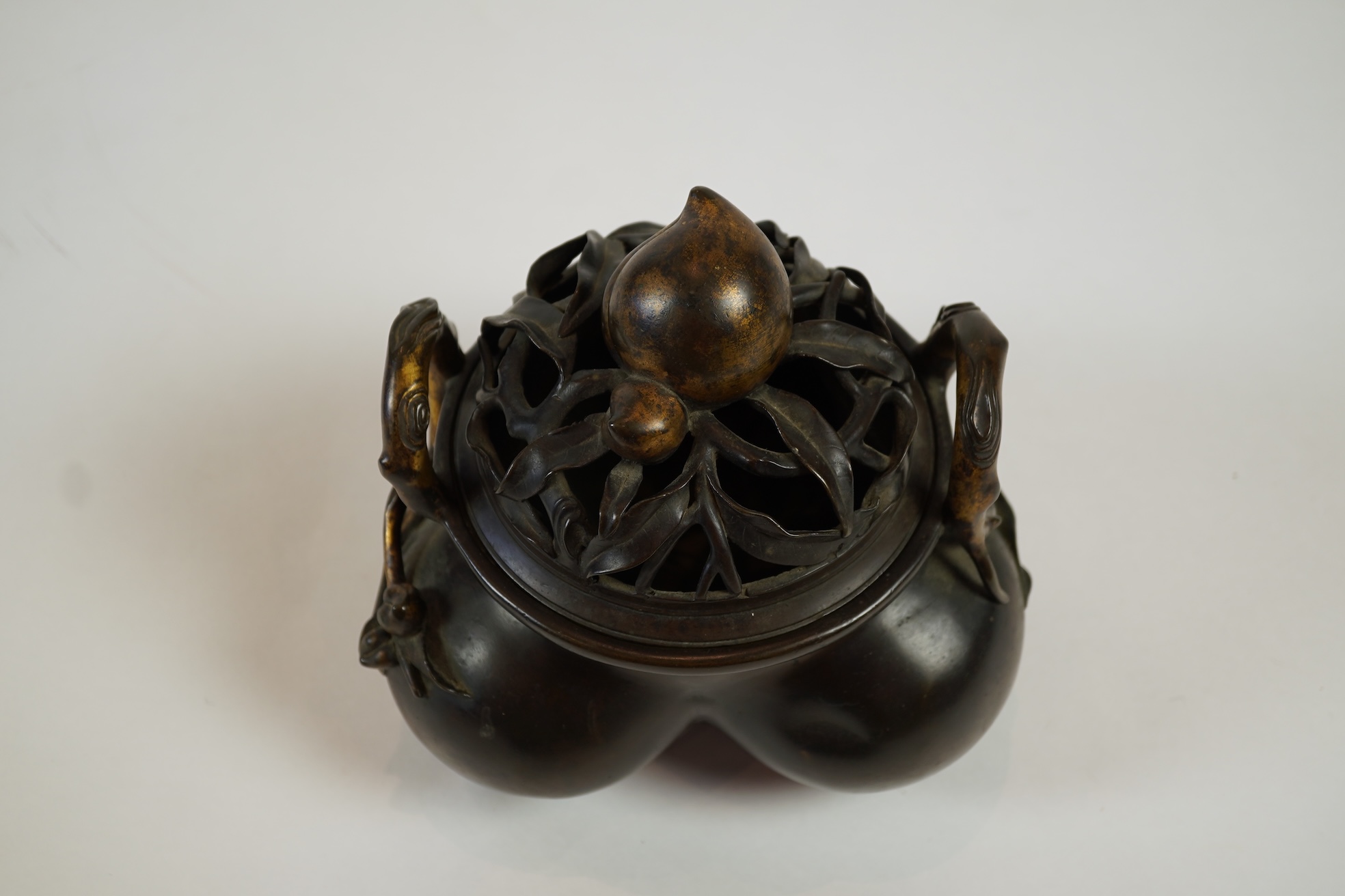 A large Chinese bronze and parcel gilt ‘peach’ censer and cover, Li, 17th/18th century